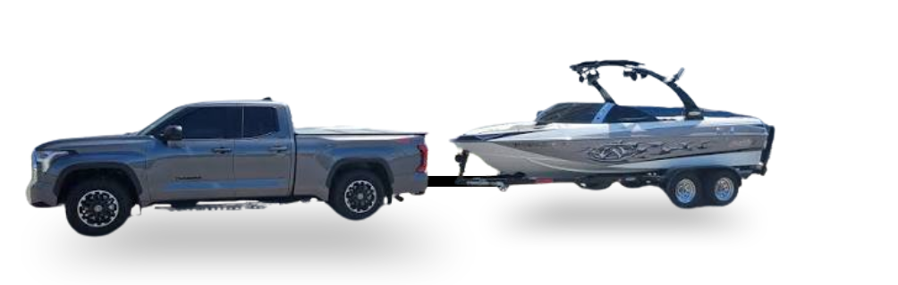 A gray truck towing a speed boat.