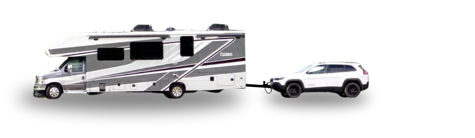 A Class C motor home towing a white Jeep Cherokee.